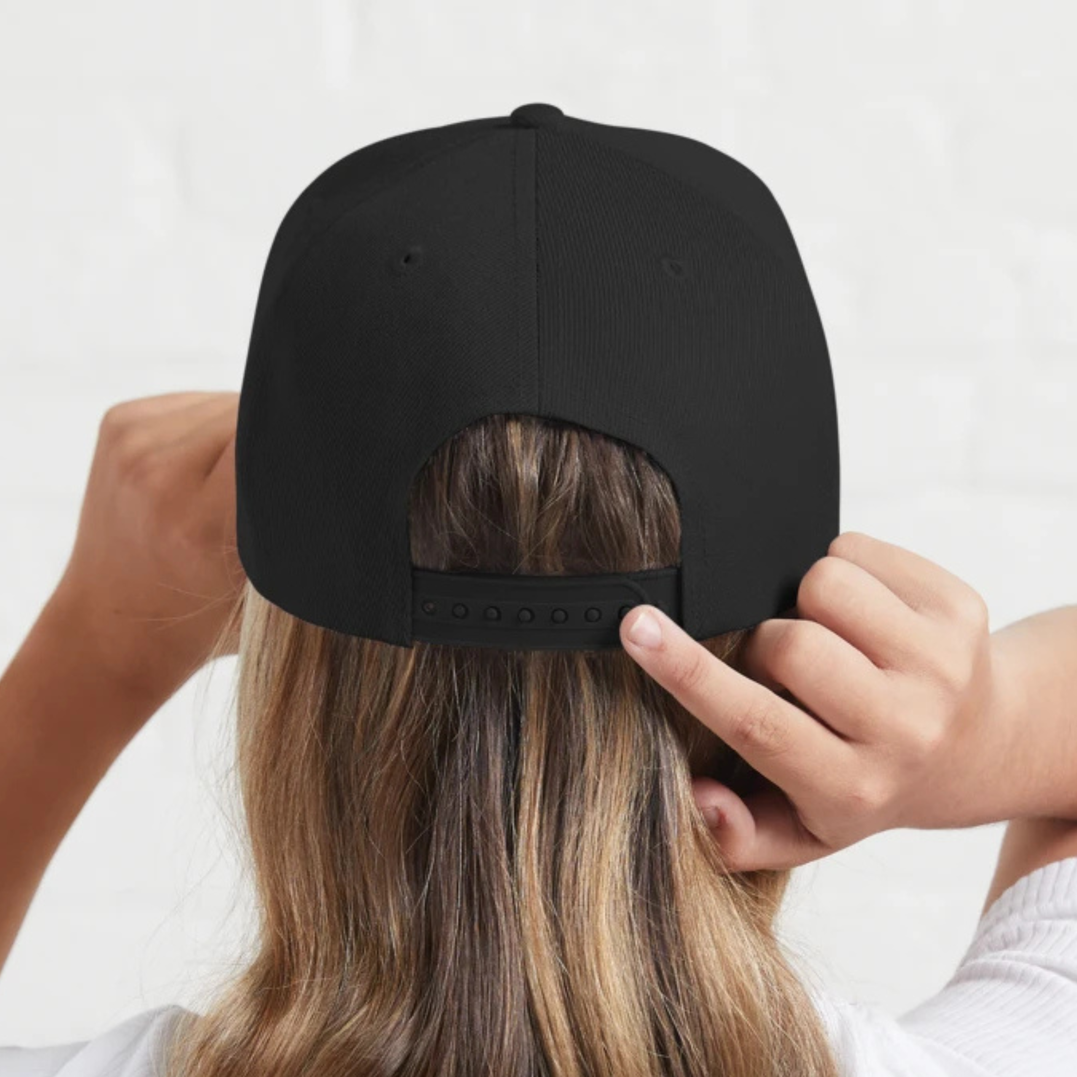 Person wearing a black baseball cap, showing the back view.